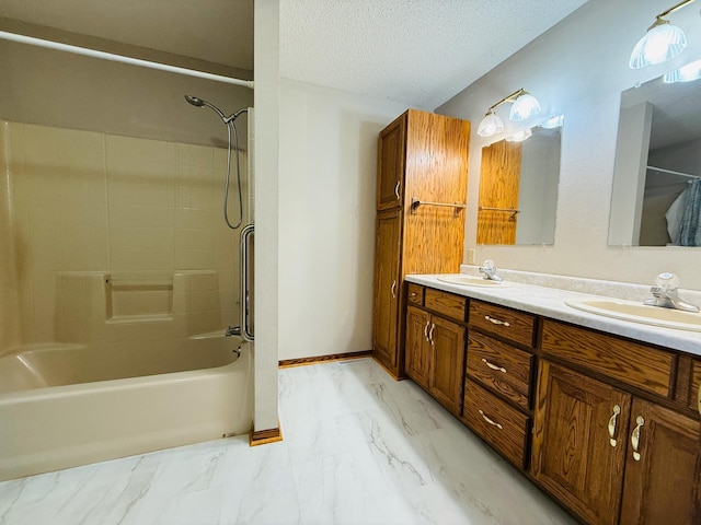 bathroom with a sink, marble finish floor, bathtub / shower combination, and a textured ceiling