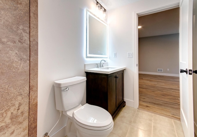 bathroom featuring baseboards, visible vents, toilet, tile patterned floors, and vanity