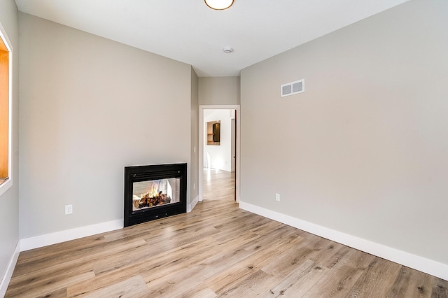 15153 Cates Lake Dr, Prior Lake, MN 55372 - unfurnished living room featuring wood finished floors, a multi sided fireplace, and baseboards