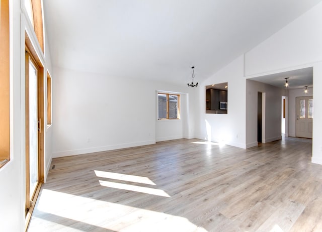 15153 Cates Lake Dr, Prior Lake, MN 55372 - unfurnished living room with a chandelier, light wood finished floors, baseboards, and high vaulted ceiling