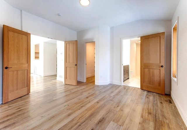 15153 Cates Lake Dr, Prior Lake, MN 55372 - unfurnished bedroom featuring light wood finished floors, baseboards, lofted ceiling, and connected bathroom