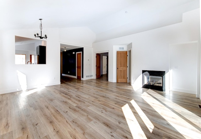 15153 Cates Lake Dr, Prior Lake, MN 55372 - unfurnished living room featuring a chandelier, a multi sided fireplace, light wood-style flooring, baseboards, and high vaulted ceiling