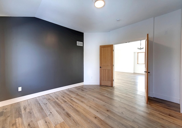 15153 Cates Lake Dr, Prior Lake, MN 55372 - spare room with wood finished floors, lofted ceiling, and baseboards