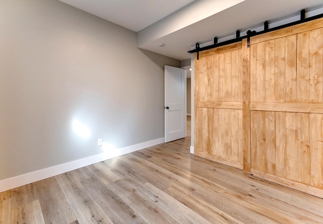 15153 Cates Lake Dr, Prior Lake, MN 55372 - unfurnished bedroom with a barn door, baseboards, and wood finished floors