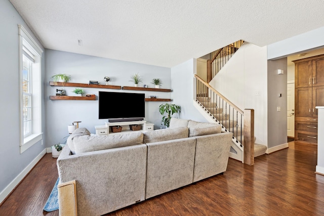 living area with dark wood-style flooring, baseboards, stairway, and a textured ceiling