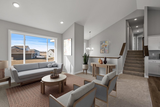 living room featuring a notable chandelier, wood finished floors, baseboards, vaulted ceiling, and stairs