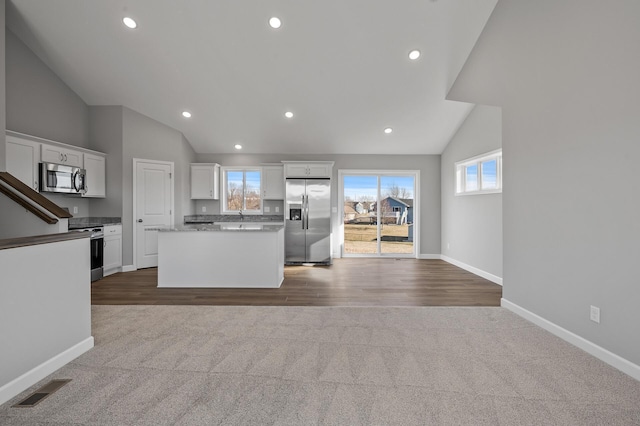 kitchen with white cabinetry, a kitchen island, appliances with stainless steel finishes, and visible vents