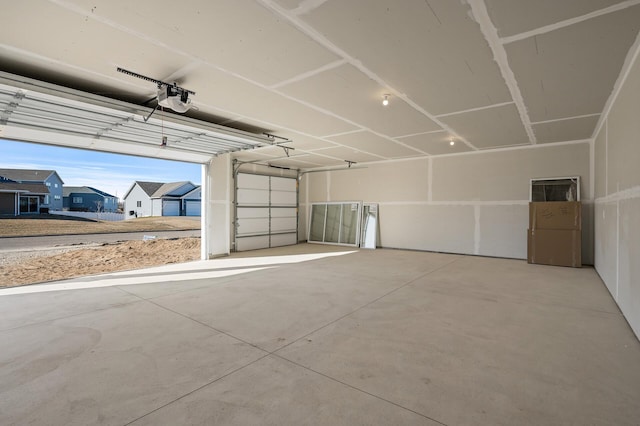 garage with a garage door opener, a residential view, and freestanding refrigerator