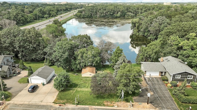 birds eye view of property featuring a water view and a wooded view