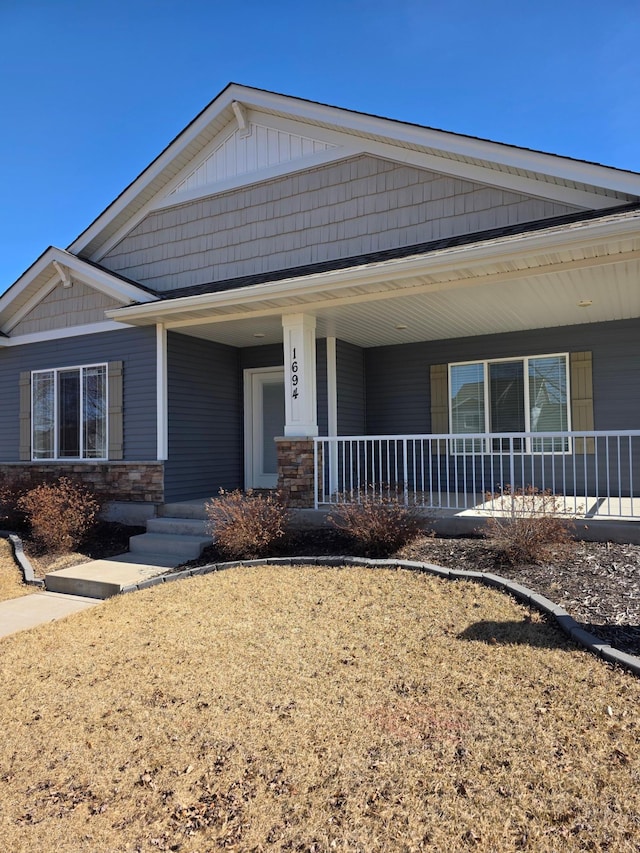 view of front of house featuring covered porch and stone siding