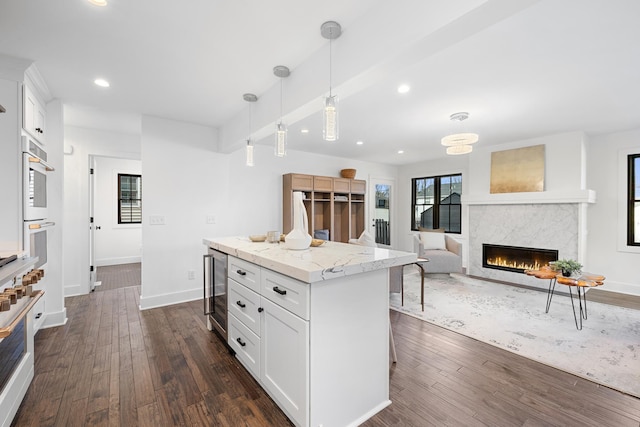 4129 Utica Ave S, Saint Louis Park, MN 55416 - kitchen with beverage cooler, a premium fireplace, dark wood-type flooring, white cabinetry, and recessed lighting