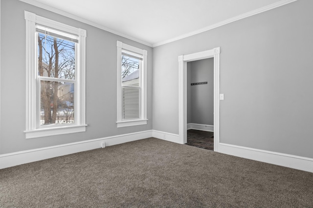 empty room with baseboards, ornamental molding, and dark colored carpet