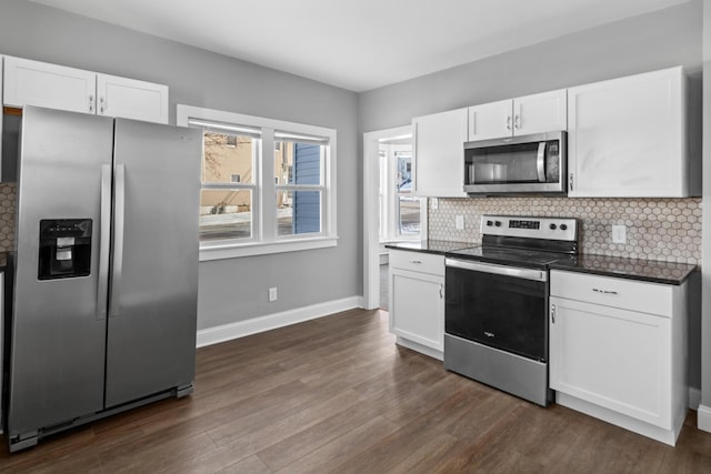 kitchen featuring appliances with stainless steel finishes, dark countertops, and white cabinetry