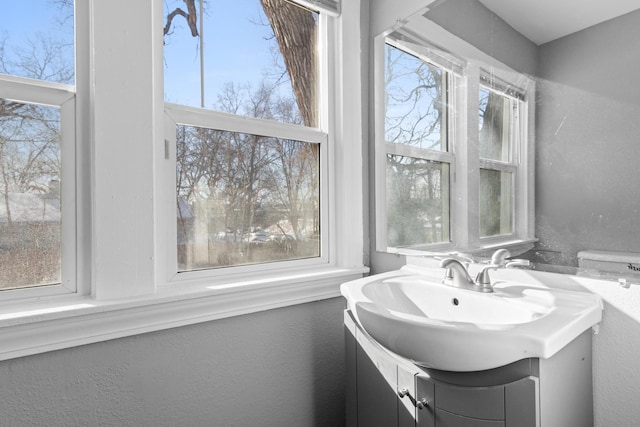 half bathroom with a textured wall and vanity