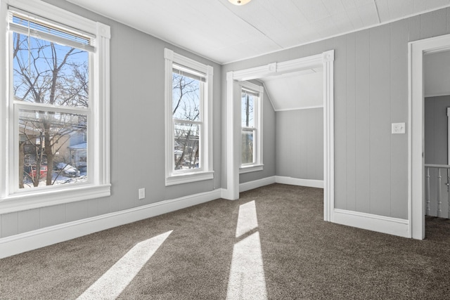 bonus room with baseboards, dark carpet, and vaulted ceiling