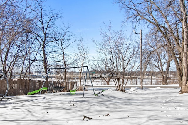 yard covered in snow featuring fence