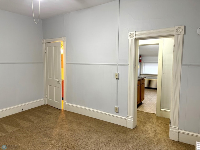 unfurnished bedroom with light carpet and radiator