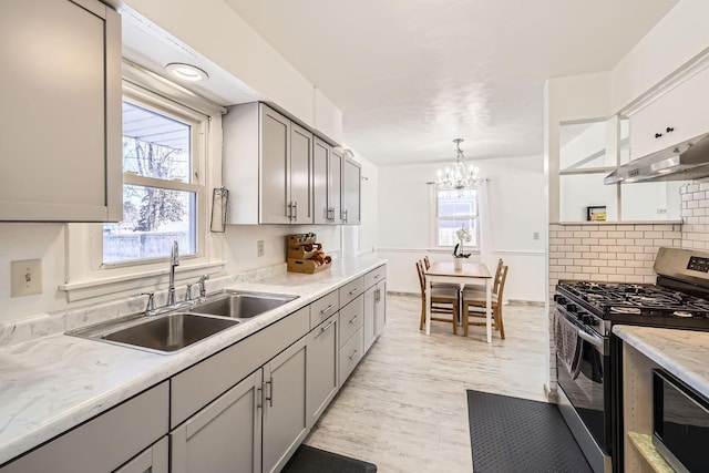 kitchen featuring pendant lighting, gray cabinetry, appliances with stainless steel finishes, a healthy amount of sunlight, and a sink