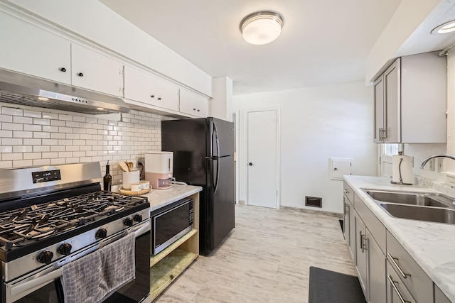 kitchen with visible vents, appliances with stainless steel finishes, gray cabinets, under cabinet range hood, and a sink