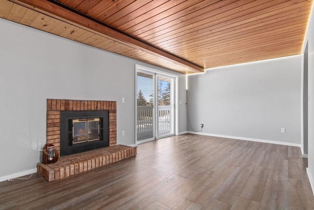 unfurnished living room with a fireplace, wood finished floors, wooden ceiling, and baseboards