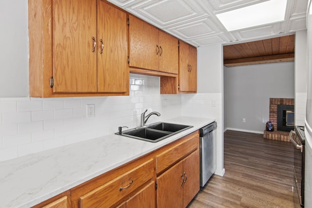 kitchen featuring stainless steel appliances, backsplash, a sink, and brown cabinets