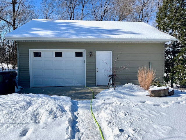 snow covered garage with a garage