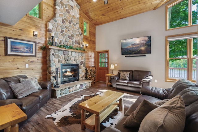 living room featuring wood ceiling, wood finished floors, wood walls, a fireplace, and high vaulted ceiling