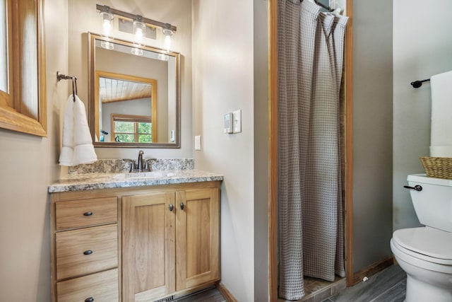 bathroom featuring toilet, a shower with shower curtain, vanity, baseboards, and vaulted ceiling