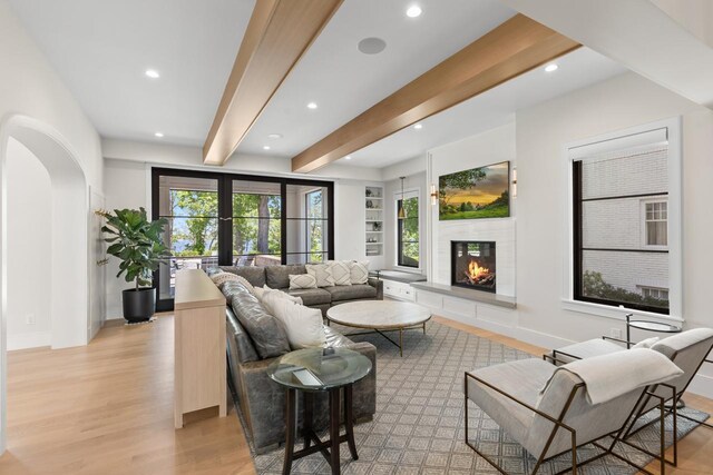 4889 Lake Harriet Pkwy, Minneapolis, MN 55419 - living area with light wood-style flooring, recessed lighting, beamed ceiling, a glass covered fireplace, and arched walkways