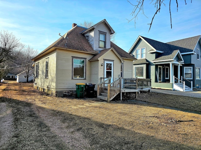 view of front of house with roof with shingles and a chimney