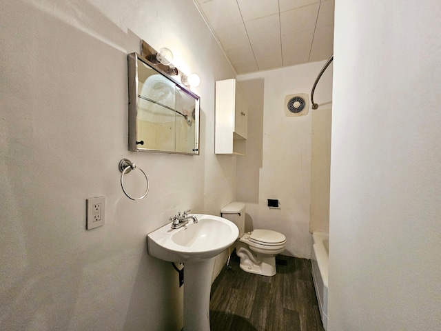 bathroom with visible vents, toilet, a sink, wood finished floors, and shower / bathtub combination