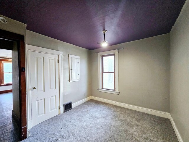 unfurnished bedroom with visible vents, carpet floors, and baseboards