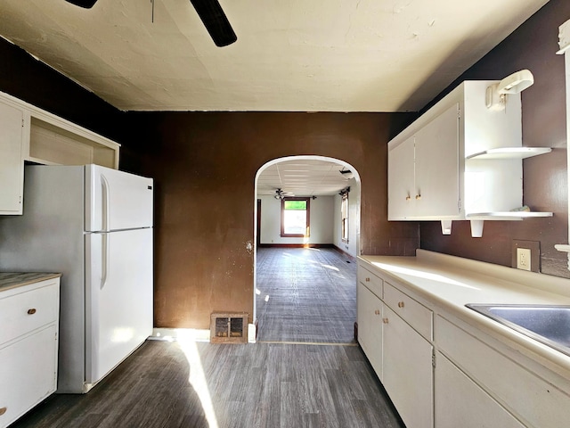 kitchen featuring arched walkways, freestanding refrigerator, ceiling fan, and open shelves