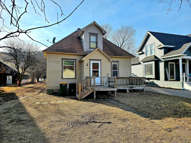 rear view of property featuring roof with shingles