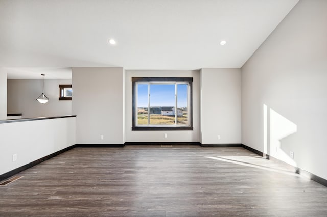 unfurnished room featuring baseboards, visible vents, dark wood-style flooring, and recessed lighting