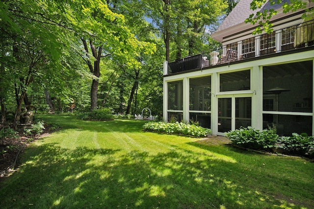 view of yard with a balcony and a sunroom