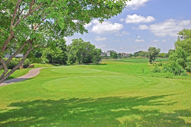 view of home's community with golf course view and a yard