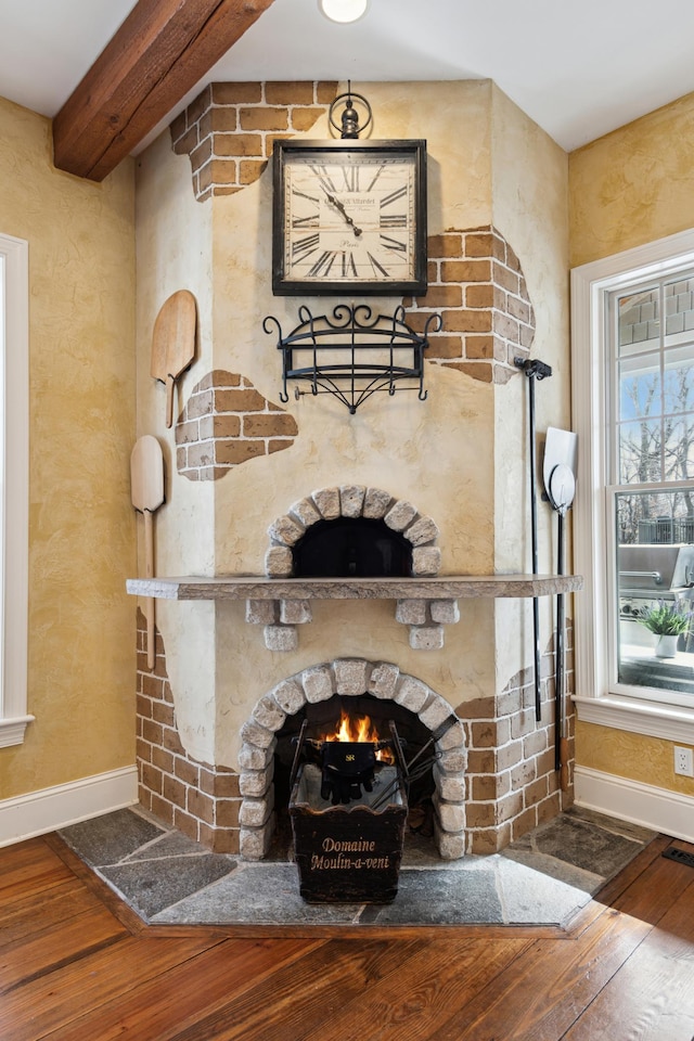 living room featuring visible vents, a large fireplace, baseboards, and wood-type flooring