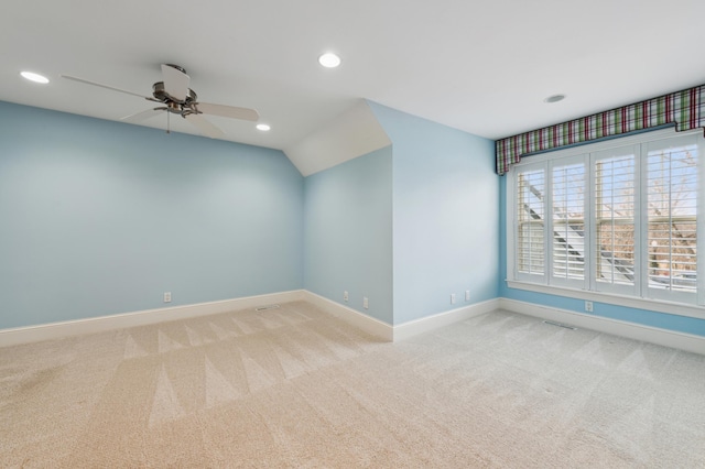 carpeted spare room with a ceiling fan, visible vents, baseboards, recessed lighting, and vaulted ceiling