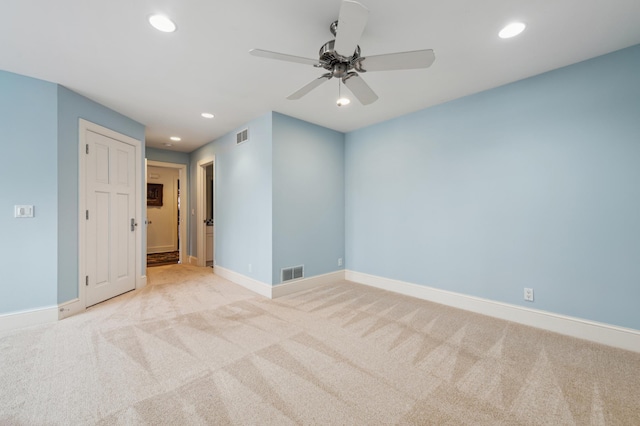 spare room featuring recessed lighting, visible vents, light carpet, and baseboards