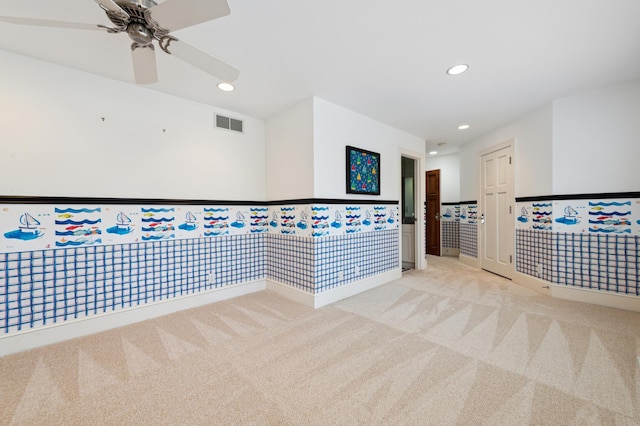 carpeted spare room featuring wainscoting, visible vents, recessed lighting, and a ceiling fan