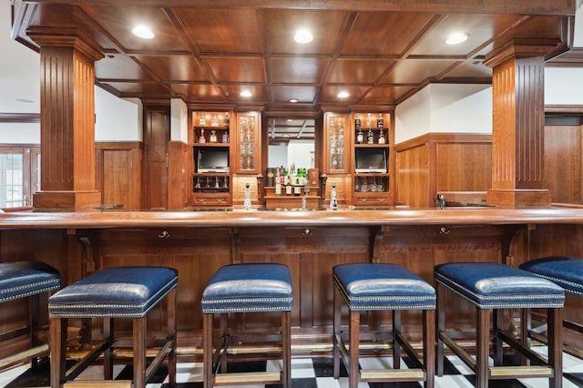 bar with decorative columns, wet bar, coffered ceiling, and wooden ceiling