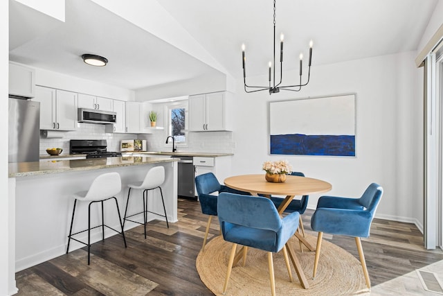 dining space with baseboards and dark wood finished floors