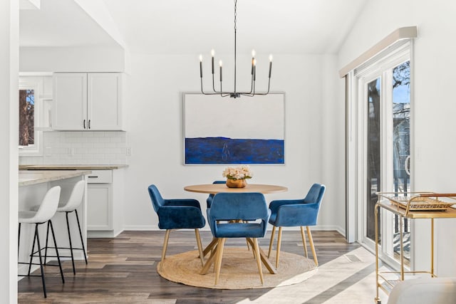 dining area with a chandelier, baseboards, and wood finished floors