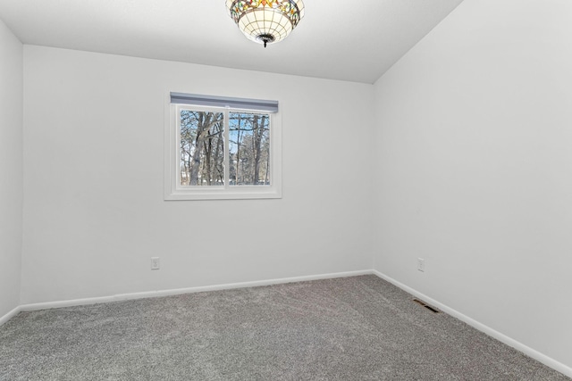 carpeted spare room featuring baseboards and visible vents