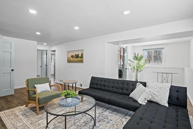 living area featuring visible vents, baseboards, dark wood-style floors, a textured ceiling, and recessed lighting