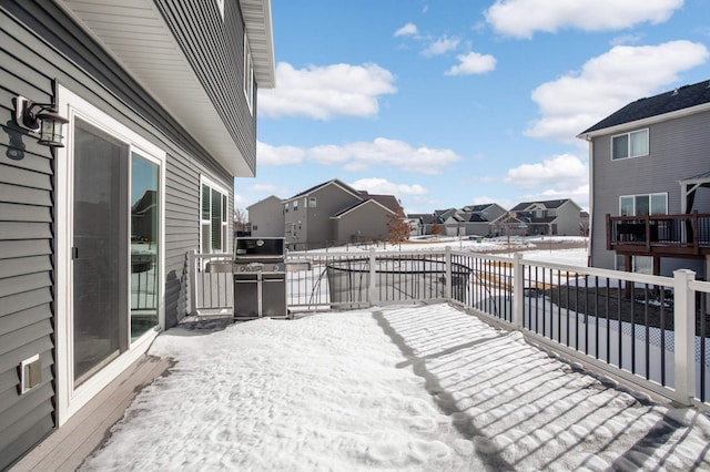 snow covered deck featuring area for grilling and a residential view