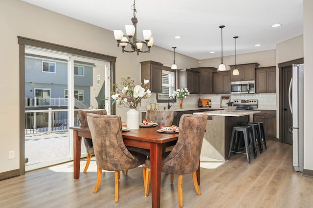 dining room with recessed lighting, baseboards, and light wood-style floors