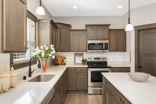 kitchen featuring a healthy amount of sunlight, appliances with stainless steel finishes, light countertops, and a sink