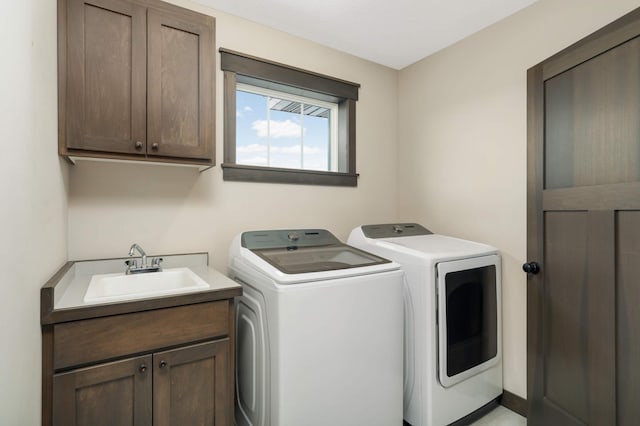 laundry area featuring washer and clothes dryer, cabinet space, and a sink